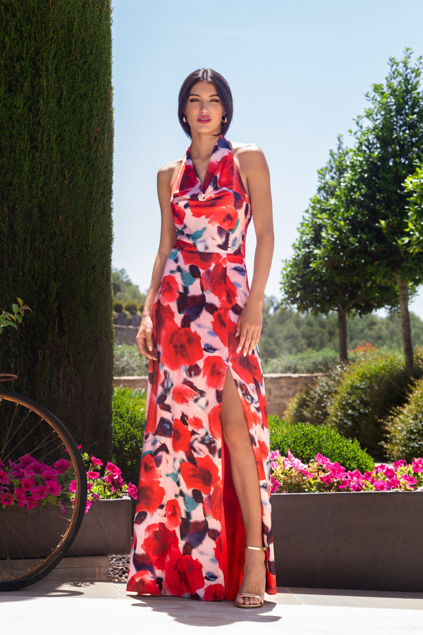 vestido largo de flores en tonos rosa, rojo y blanco, ideal para bodas, comuniones y eventos especiales. Su diseño con escote halter y abertura lateral realza la figura, combinando elegancia y frescura para un look sofisticado.